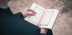 back of a person with a prayer book open to a page.