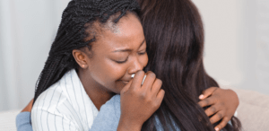 two folks embracing sad hug showing support