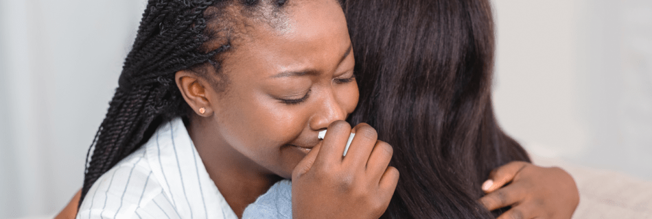 two folks embracing sad hug showing support