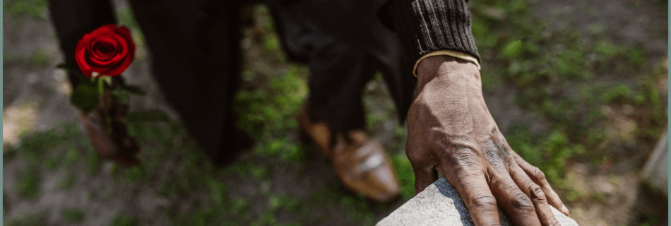 Hand touching a tombstone